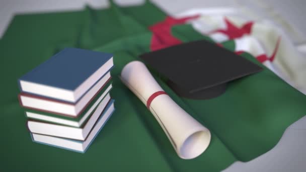 Tapa de graduación, libros y diploma en la bandera argelina. La educación superior en Argelia relacionados con la animación 3D conceptual — Vídeos de Stock
