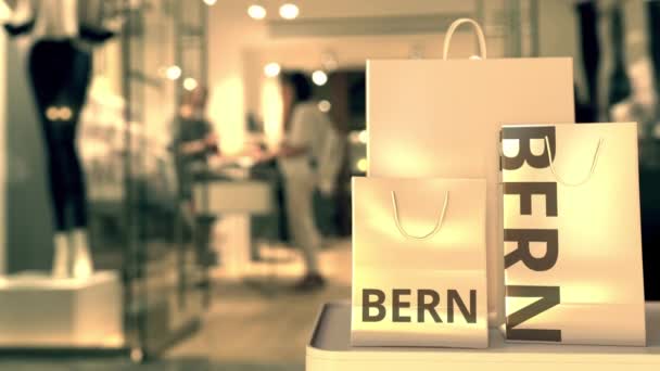 Sacchetti della spesa con didascalia di Berna contro l'ingresso sfocato del negozio. Shopping in Svizzera animazione 3D correlata — Video Stock
