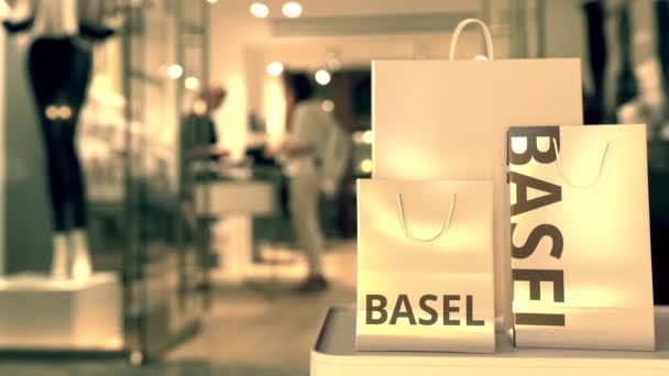 Papperspåsar med Basel bildtext mot suddig butik entré. Detaljhandel i Schweiz relaterad konceptuell 3D-animation — Stockvideo