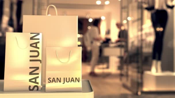 Torby sklepowe z napisem San juan przeciwko zamazanemu wejściu do sklepu. Zakupy w Portoryko związane z animacją 3D — Wideo stockowe