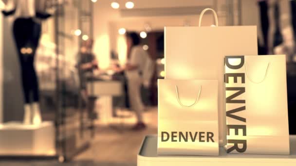 Papírové nákupní tašky s denverským titulem proti rozmazanému vchodu do obchodu. Retail in the United States related concept 3d animation — Stock video