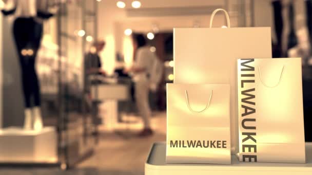Paper shopping bags with Milwaukee caption against blurred store entrance. Retail in the United States related 3D animation — Stock Video