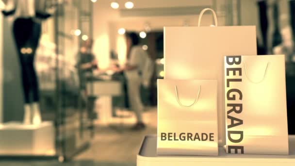 Papírové nákupní tašky s bělehradským titulem proti rozmazanému vstupu do obchodu. Maloobchod v Srbsku související 3D animace — Stock video