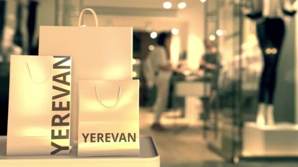 Paper shopping bags with Yerevan caption against blurred store entrance. Retail in Armenia related conceptual 3D animation — Stock Video