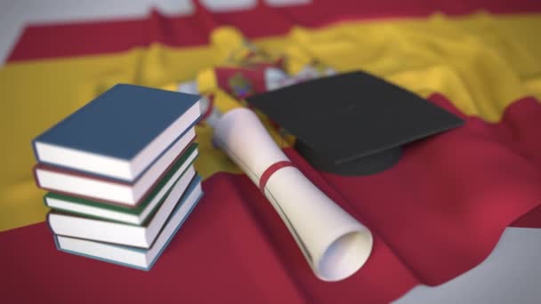 Tapa de graduación, libros y diploma en la bandera de España. La educación superior en España relacionada con la animación conceptual 3D — Vídeos de Stock