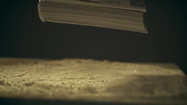 Super-Zeitlupenaufnahme eines Buches, das auf einen staubigen Holztisch fällt, Nahaufnahme — Stockvideo