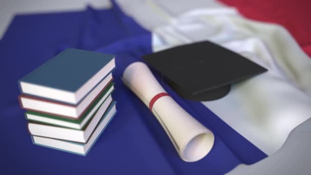 Czapka dyplomowa, książki i dyplom na francuskiej fladze. Szkolnictwo wyższe we Francji powiązana konceptualna animacja 3D — Wideo stockowe