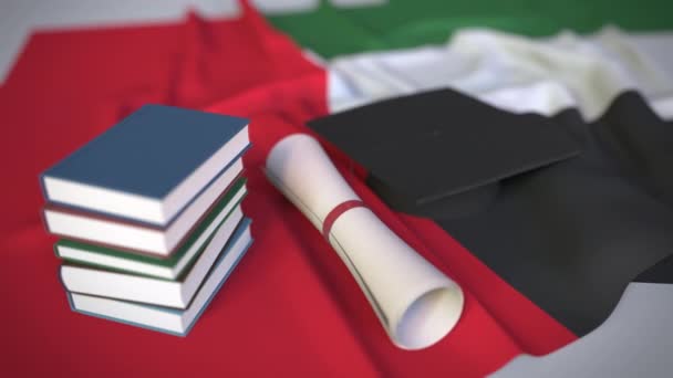 Mezuniyet şapkası, bayrağın üzerinde kitaplar ve diploma. Birleşik Arap Emirlikleri Uae 'de yüksek öğrenim ilgili kavramsal 3d animasyon — Stok video