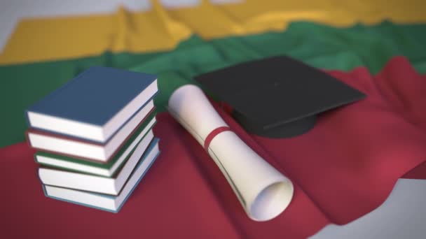 Berretto di laurea, libri e diploma sulla bandiera lituana. L'istruzione superiore in Lituania relativa all'animazione concettuale 3D — Video Stock