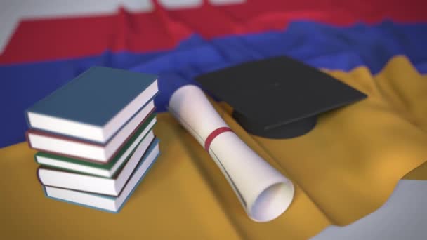 Tapa de graduación, libros y diploma en la bandera armenia. Educación superior en Armenia relacionada con la animación 3D conceptual — Vídeo de stock