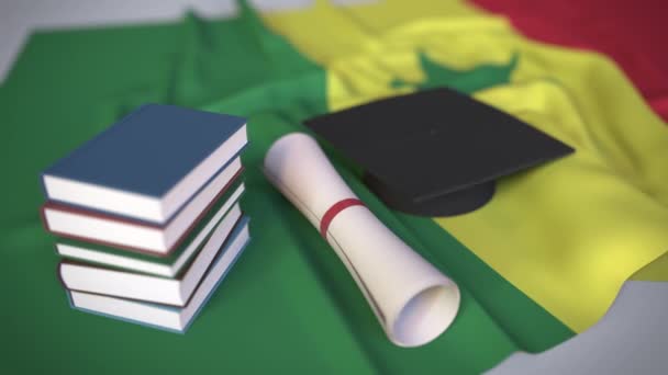 Boné de formatura, livros e diploma na bandeira senegalesa. Educação superior em Senegal — Vídeo de Stock