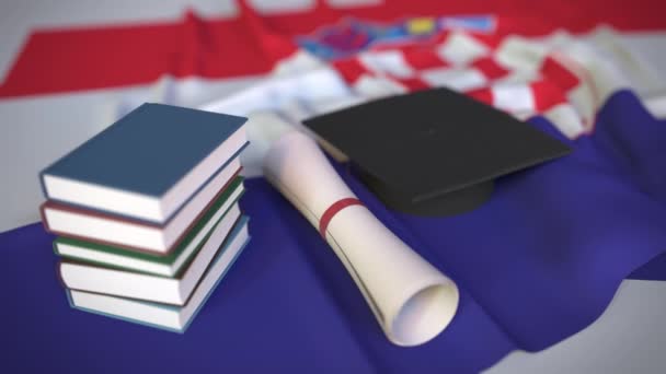 Boné de formatura, livros e diploma na bandeira croata. Ensino superior na Croácia relacionados animação 3D conceitual — Vídeo de Stock