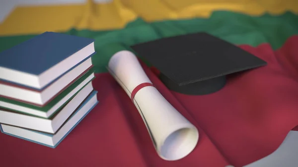 Выпускной колпак, книги и диплом о флаге Литвы. Высшее образование в Литве — стоковое фото