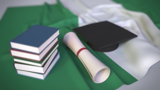 Tapa de graduación, libros y diploma en la bandera nigeriana. La educación superior en Nigeria relacionados con la animación 3D conceptual — Vídeos de Stock