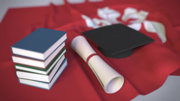 Выпускной колпак, книги и диплом на флаге. Концептуальная 3D анимация высшего образования в Гонконге — стоковое видео