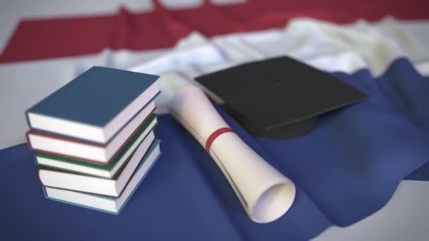 Tapa de graduación, libros y diploma en la bandera holandesa. La educación superior en los Países Bajos relacionados con la animación 3D conceptual — Vídeos de Stock