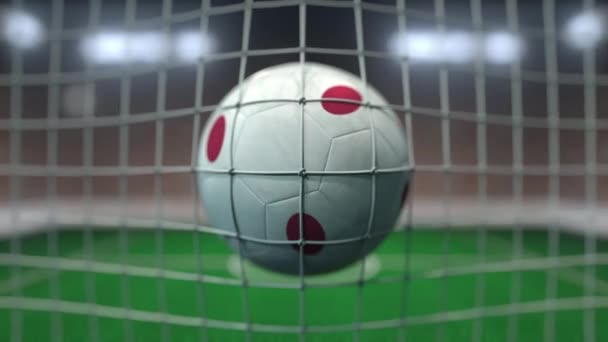 Fotboll med flaggor av Japan träffar målnät. Slow motion 3D-animering — Stockvideo