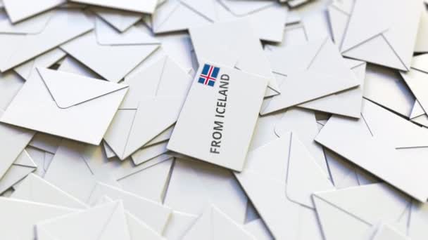 Envelop met uit IJsland tekst op stapel van andere enveloppen. Internationale post gerelateerde conceptuele 3D-animatie — Stockvideo