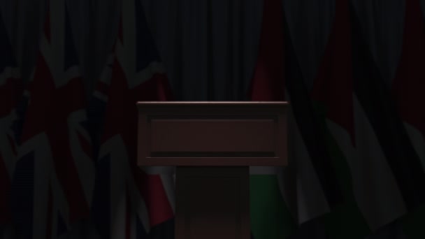 Veel vlaggen van Jordanië en het Verenigd Koninkrijk achter spreker tribune, 3D-animatie — Stockvideo