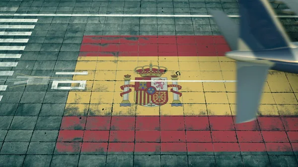 Aerial view of a landing airplane revealing flag of Spain on the airfield of an airport. Air travel related conceptual 3D rendering — Stock Photo, Image