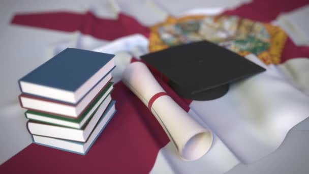 Klobouk, knihy a diplom na floridské vlajce. Vysokoškolské vzdělání v konceptuální 3D animaci související s USA — Stock video