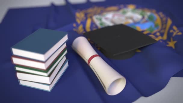 Graduiertenmütze, Bücher und Diplom auf der Flagge von New Hampshire. Hochschulbildung in den USA verwandte konzeptionelle 3D-Animation — Stockvideo