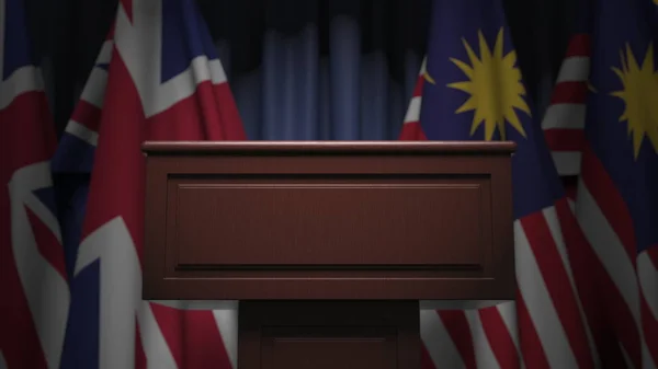 Banderas de Malasia y el Reino Unido y tribuna, representación 3D —  Fotos de Stock