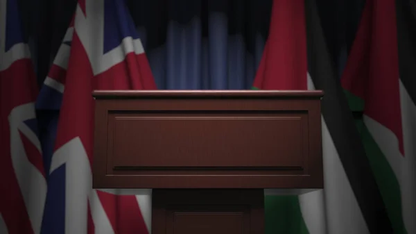 Många flaggor av Jordanien och Storbritannien bakom högtalartribun, 3d rendering — Stockfoto