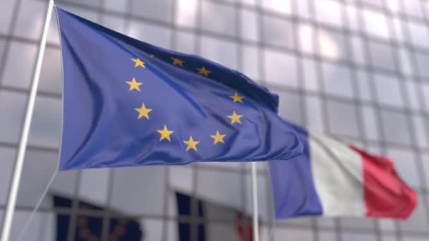 Waving flags of the European Union EU and France in front of a modern skyscraper facade — Stock Video