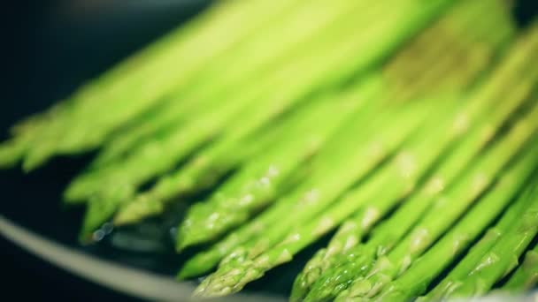 프라이팬 위에 녹색 아스파라거스를 볶고 있는 매크로 샷 — 비디오
