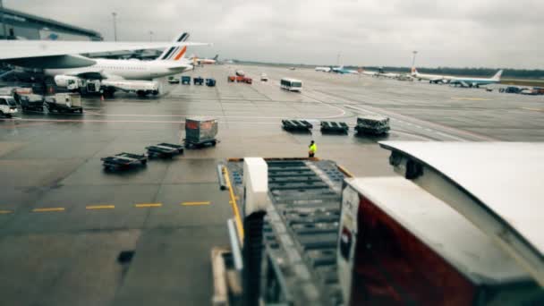 Aviones y vehículos utilitarios estacionados desconocidos en el aeropuerto internacional. Carga de suministros de vuelo al avión comercial — Vídeos de Stock