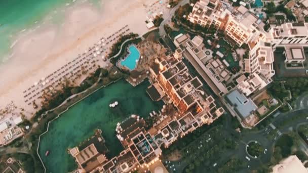 DUBAI, UNITED ARAB EMIRATES - DECEMBER 25, 2019. Aerial view of the Madinat Jumeirah resort and Burj Al Arab luxury hotel at sunset — ストック動画