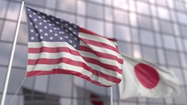 Ondeando banderas de los Estados Unidos y Japón frente a una moderna fachada de rascacielos — Vídeos de Stock