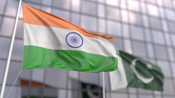 Mávání vlajkami Indie a Pákistánu před moderní fasádou mrakodrapu — Stock video