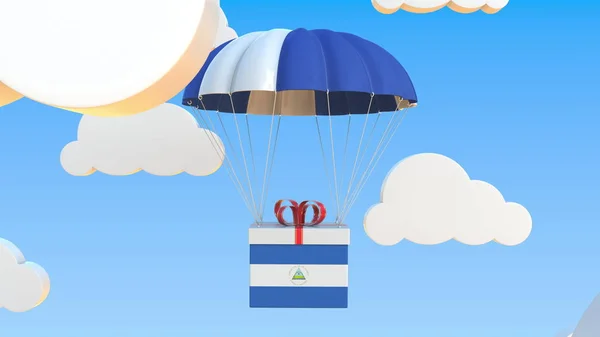 Ulusal Nikaragua bayrağı taşıyan bir kutu paraşütle düşüyor. 3d oluşturma — Stok fotoğraf