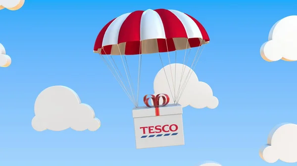 O logotipo da TESCO na caixa móvel se move sob paraquedas. Renderização 3D editorial — Fotografia de Stock