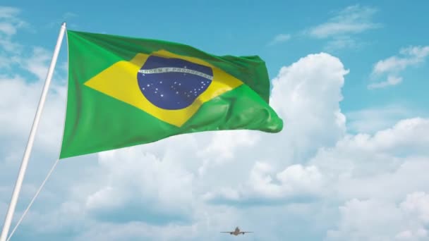 Avião comercial pousando atrás da bandeira brasileira. Turismo no Brasil — Vídeo de Stock