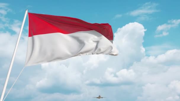 Avião comercial a aterrar atrás da bandeira nacional da Indonésia. Turismo na Indonésia — Vídeo de Stock