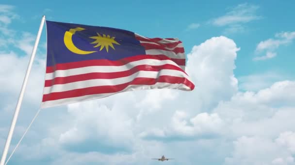 Самолет прибывает в аэропорт с национальным флагом Малайзии. Туризм Малайзии — стоковое видео