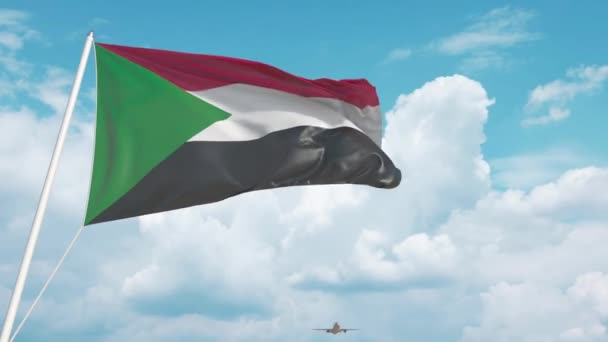 Avión comercial aterrizando detrás de la bandera sudanesa. Turismo en Sudán — Vídeo de stock