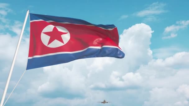 Avión comercial aterrizando detrás de la bandera de Corea del Norte — Vídeo de stock