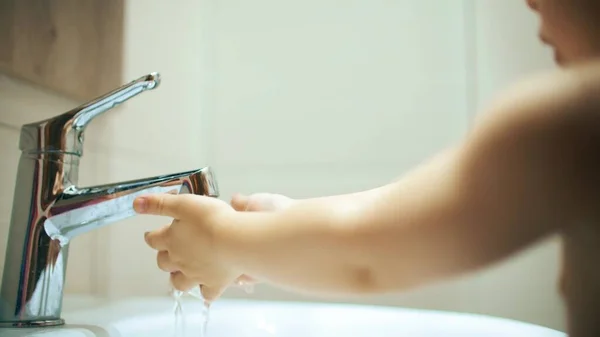 Kleines Mädchen wäscht sich die Hände mit Leitungswasser — Stockfoto