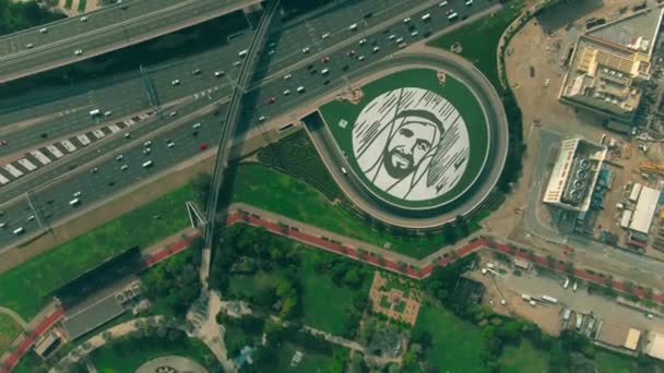 DUBAI, EMIRATOS ÁRABES UNIDOS - 26 DE DICIEMBRE DE 2019. Vista aérea de arriba hacia abajo del gran retrato del jeque Zayed bin Sultan Al Nahyan en el suelo cerca de la autopista — Vídeos de Stock