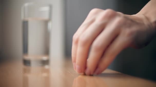 Frau steckt Brausemittel oder Vitaminpille in Glas Wasser — Stockvideo