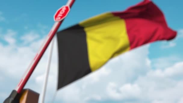 Барьерные ворота закрываются флагом Бельгии на заднем плане. Запрет на въезд в Бельгию — стоковое видео