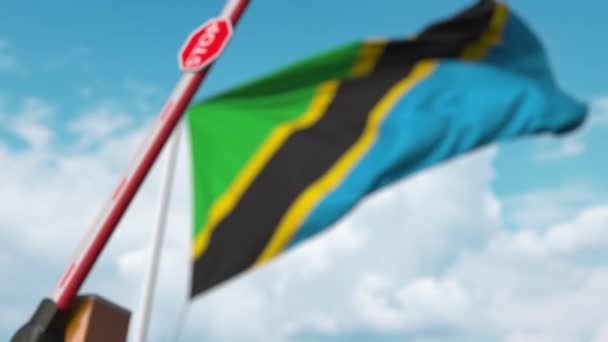 Barrière de fermeture avec panneau d'arrêt contre le drapeau tanzanien. Passage limité de la frontière ou certaines interdictions en Tanzanie — Video