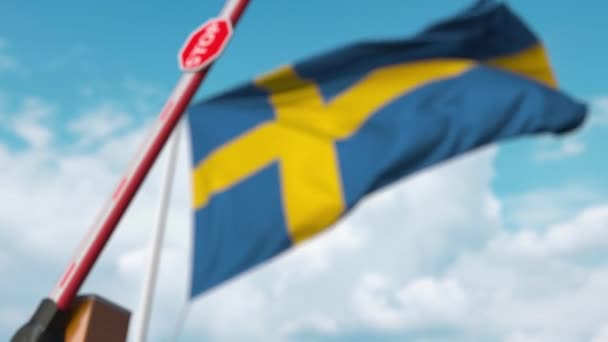 Barrera de cierre con señal de stop contra la bandera sueca. Cruce fronterizo restringido o cierta prohibición en Suecia — Vídeo de stock