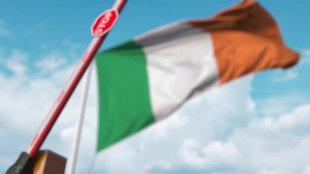 Puerta de boom cerrada en el fondo de la bandera irlandesa. Entrada restringida o cierta prohibición en Irlanda — Vídeos de Stock