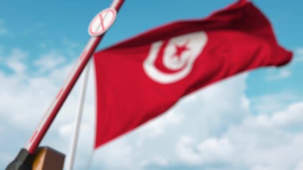 Fechando barreira boom com parar sinal de imigração contra a bandeira tunisiana. Restrição da passagem das fronteiras ou proibição de imigração na Tunísia — Vídeo de Stock