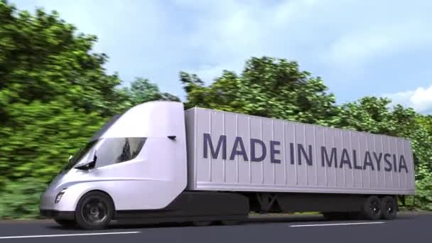 Caminhão semi-reboque elétrico moderno com texto MADE IN MALAYSIA na lateral. Malásia importar ou exportar relacionados loopable animação 3D — Vídeo de Stock